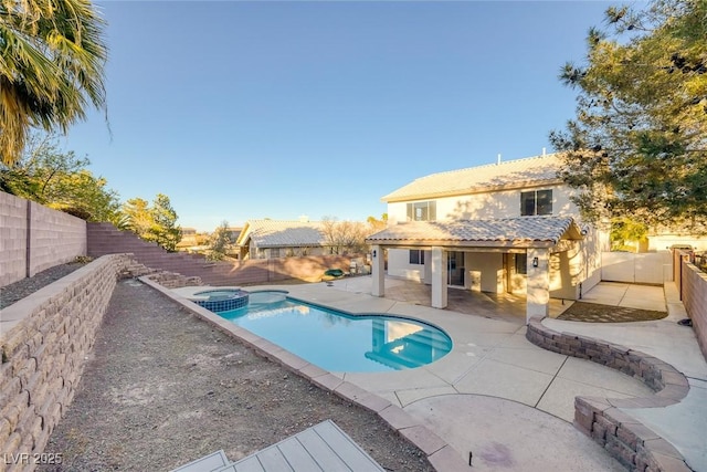 view of swimming pool featuring a patio area, a pool with connected hot tub, and a fenced backyard