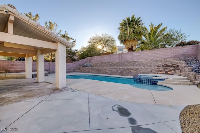 view of pool featuring a patio, a fenced backyard, and a pool with connected hot tub