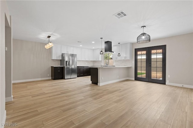 kitchen with visible vents, stainless steel fridge with ice dispenser, light countertops, french doors, and white cabinetry