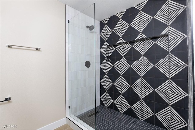 bathroom with baseboards and tiled shower