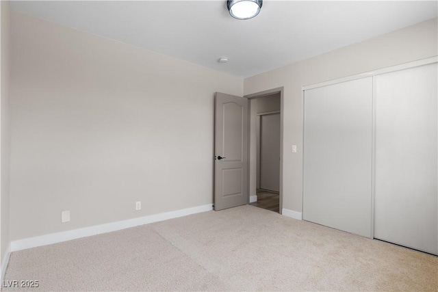 unfurnished bedroom with a closet, baseboards, and carpet flooring