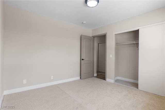 unfurnished bedroom featuring carpet flooring, baseboards, and a closet