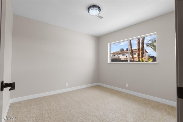 spare room featuring visible vents, baseboards, and light colored carpet