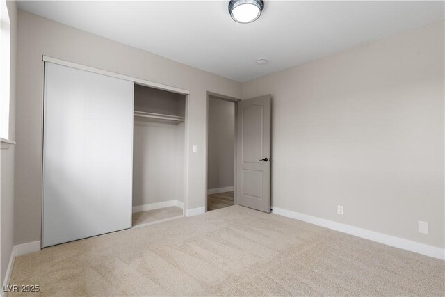 unfurnished bedroom with a closet, baseboards, and carpet