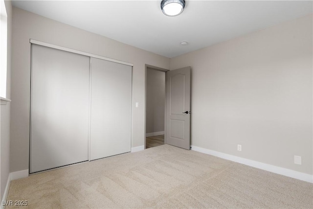 unfurnished bedroom featuring carpet, a closet, and baseboards