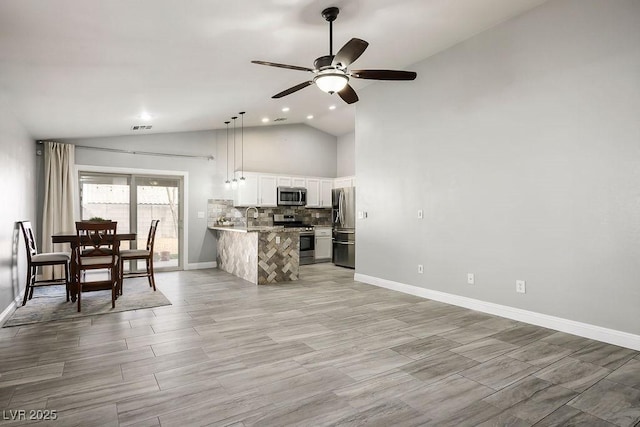 kitchen with tasteful backsplash, visible vents, a peninsula, white cabinets, and stainless steel appliances