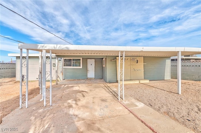 ranch-style house with an attached carport and fence