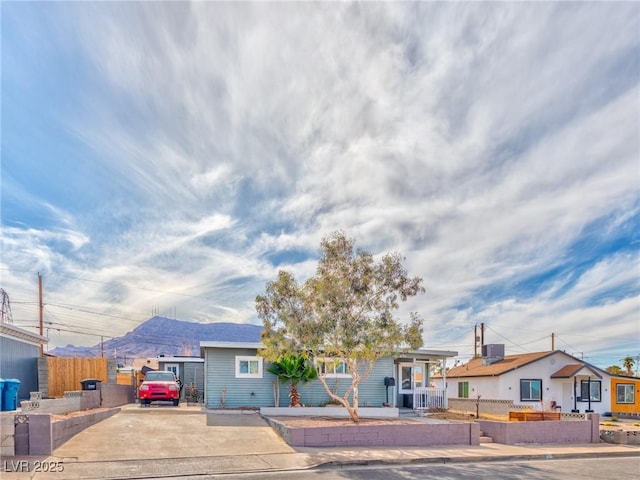 ranch-style house featuring a mountain view and fence