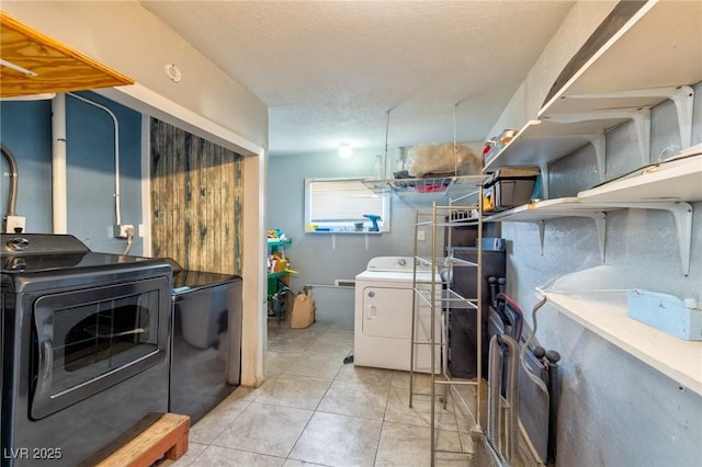 laundry area with washer and dryer, laundry area, tile patterned flooring, and a textured ceiling