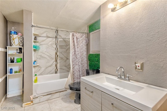 bathroom featuring tile patterned floors, vanity, shower / tub combo with curtain, and a textured wall