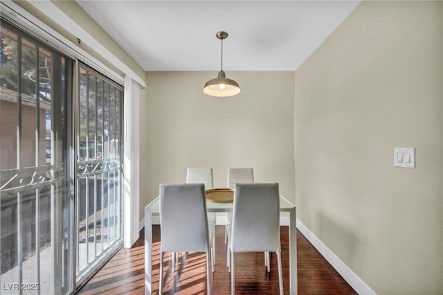 dining area with baseboards, a healthy amount of sunlight, and wood finished floors