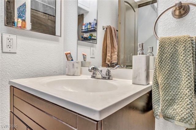 bathroom featuring vanity and a textured wall