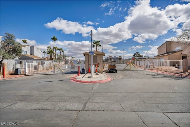 view of road featuring curbs, a residential view, and a gated entry