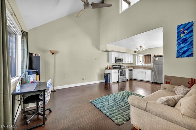 living area featuring ceiling fan, high vaulted ceiling, baseboards, and dark wood-style flooring