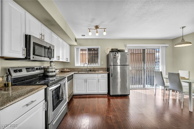 kitchen featuring a sink, a textured ceiling, dark wood-style floors, white cabinetry, and stainless steel appliances