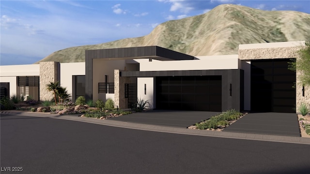 contemporary home featuring a mountain view, an attached garage, and concrete driveway