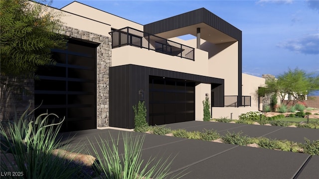 contemporary home with a balcony, a garage, and stucco siding