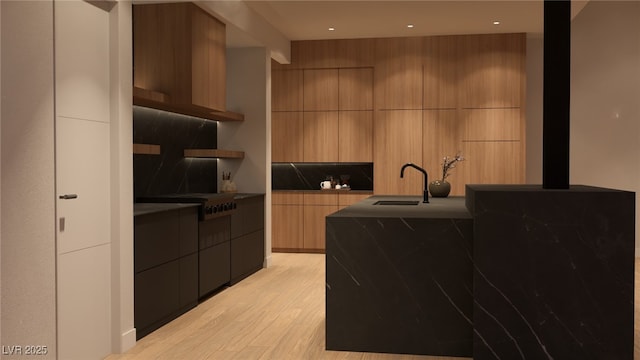 kitchen with dark countertops, modern cabinets, tasteful backsplash, and a sink