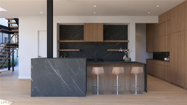 bar with stairway, light wood finished floors, backsplash, and a sink