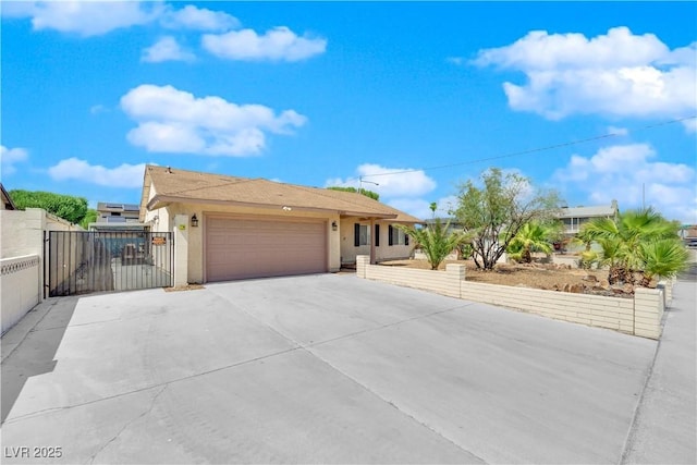 ranch-style home with fence, concrete driveway, stucco siding, an attached garage, and a gate