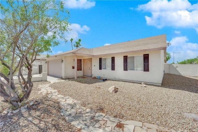 single story home featuring a garage, stucco siding, and fence