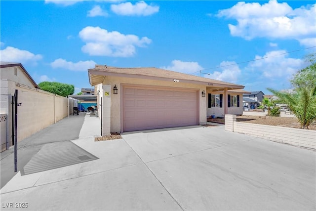 single story home with stucco siding, concrete driveway, an attached garage, and fence