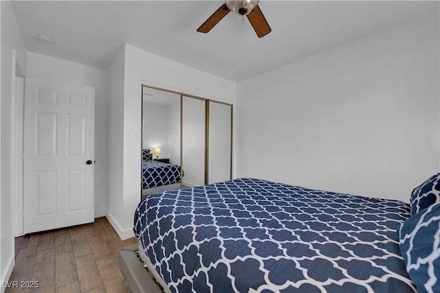 bedroom featuring a closet, baseboards, ceiling fan, and wood finished floors