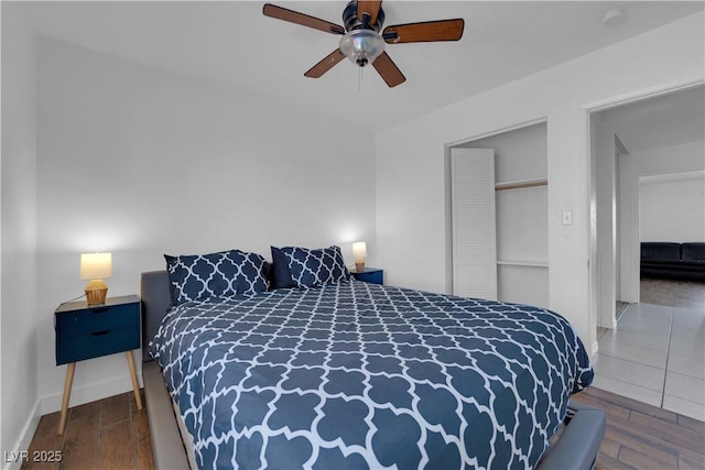 bedroom featuring ceiling fan, baseboards, and wood finished floors