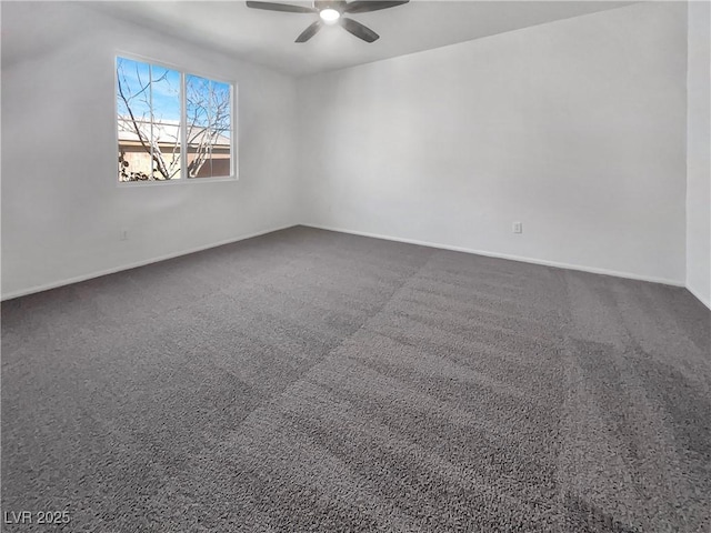 empty room featuring baseboards, a ceiling fan, and dark colored carpet