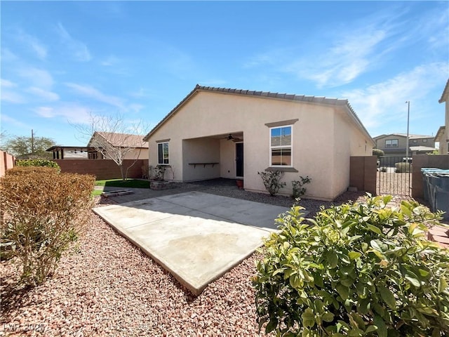 back of house featuring stucco siding, a ceiling fan, a gate, fence, and a patio area