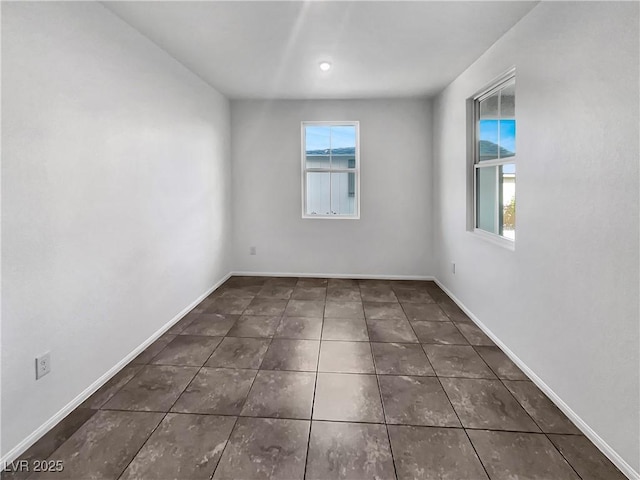 tiled spare room with a wealth of natural light and baseboards