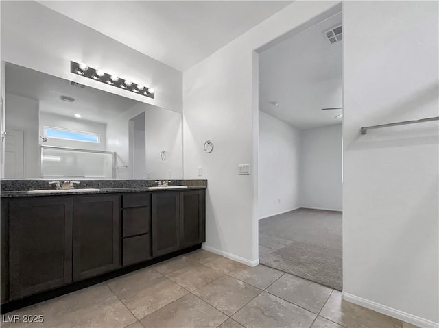 full bathroom featuring double vanity, visible vents, baseboards, and a sink