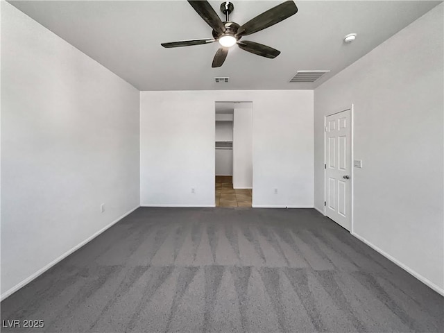 spare room with baseboards, carpet, visible vents, and ceiling fan