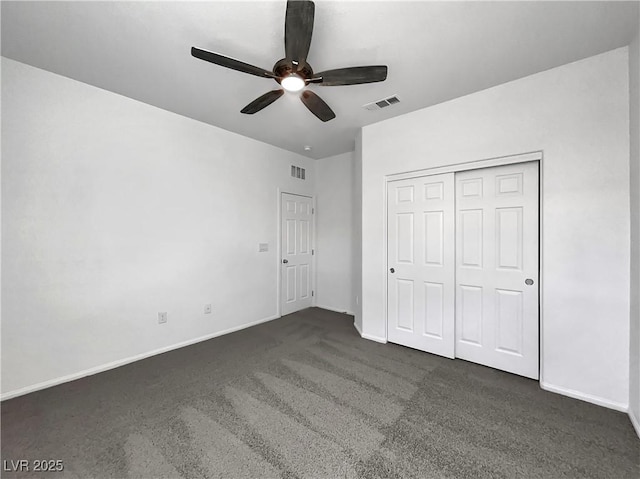 unfurnished bedroom featuring visible vents, dark carpet, and baseboards