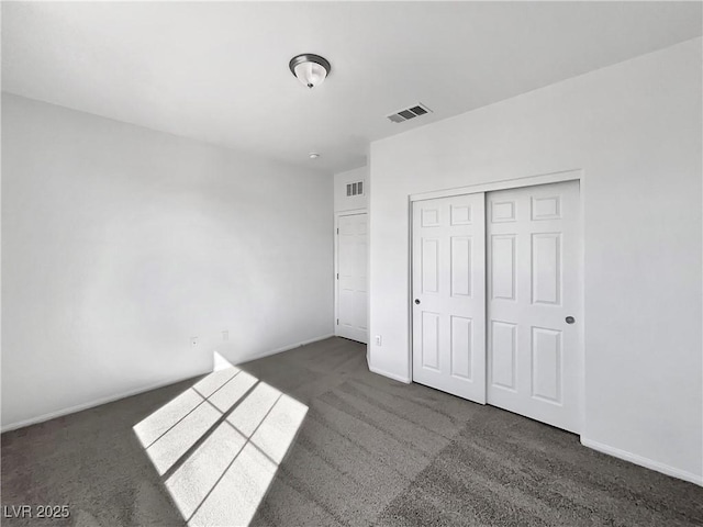 unfurnished bedroom with carpet flooring, baseboards, visible vents, and a closet