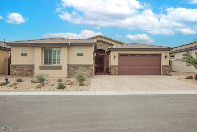 view of front of home featuring a gate, stone siding, and stucco siding