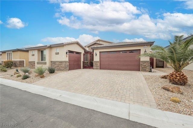 view of front facade featuring decorative driveway, an attached garage, stone siding, and stucco siding