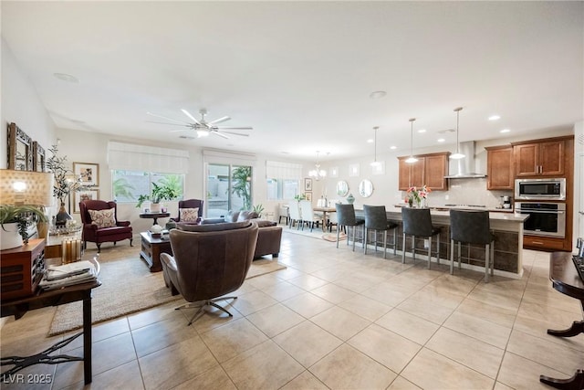 living room with ceiling fan with notable chandelier, light tile patterned floors, and recessed lighting