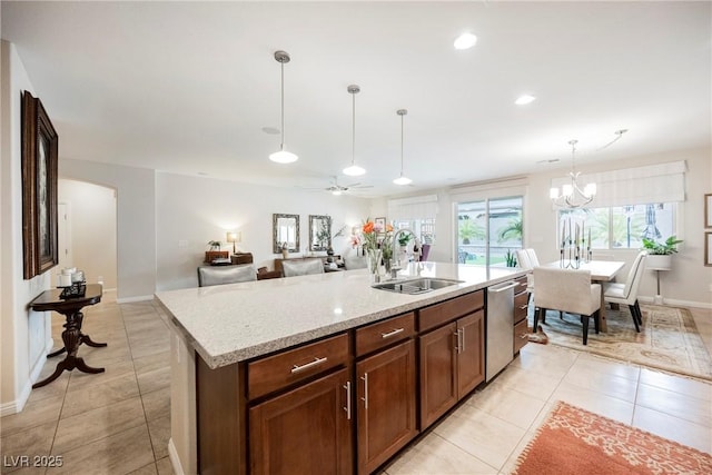 kitchen with light tile patterned floors, decorative light fixtures, stainless steel dishwasher, and a sink