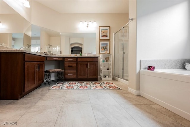 bathroom with tile patterned floors, a garden tub, a stall shower, and vanity