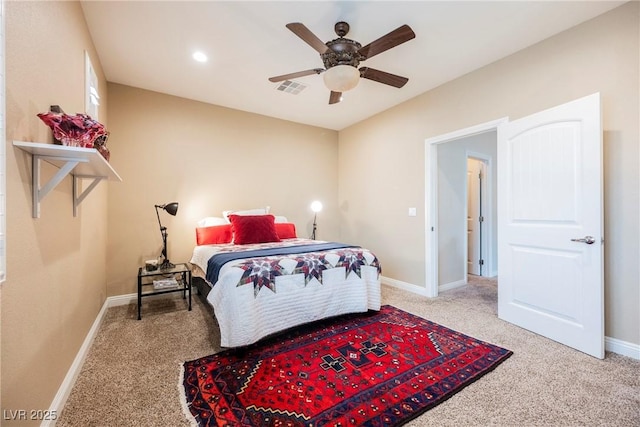 bedroom featuring visible vents, light colored carpet, a ceiling fan, and baseboards