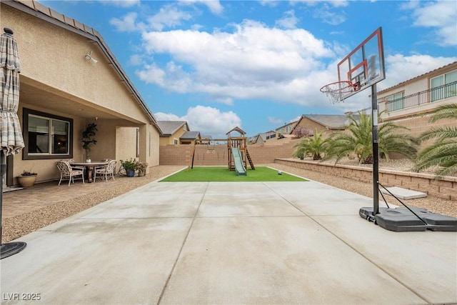 view of patio with a playground and a fenced backyard