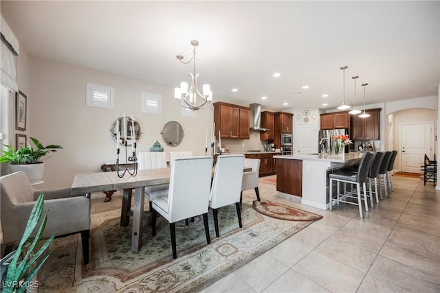 dining area featuring arched walkways, a chandelier, recessed lighting, and light tile patterned floors