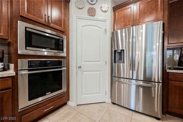 kitchen featuring light countertops, light tile patterned floors, and appliances with stainless steel finishes