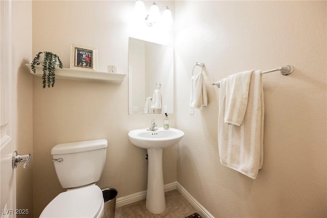 bathroom featuring tile patterned flooring, toilet, and baseboards