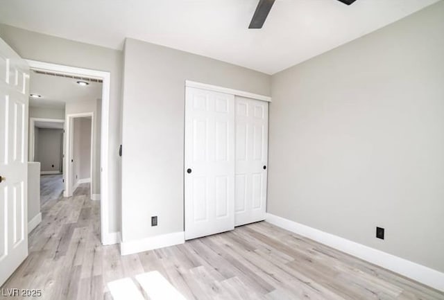 unfurnished bedroom featuring light wood-type flooring, baseboards, a closet, and ceiling fan