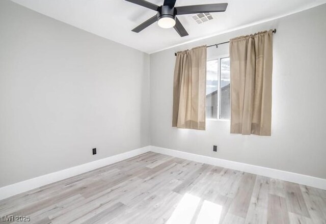 spare room with wood finished floors, baseboards, and visible vents