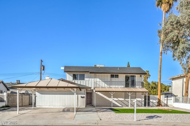 view of front facade featuring a carport, fence, and a gate