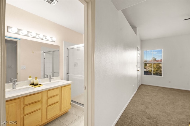 bathroom featuring tile patterned flooring, a shower stall, double vanity, and a sink