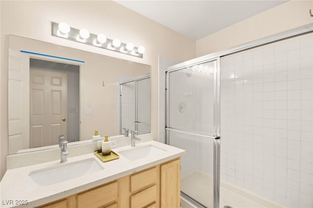 bathroom with double vanity, a stall shower, and a sink